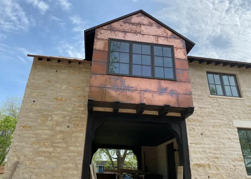 Copper metal panel facade on a stone building for Skylight Installation in Mitchell